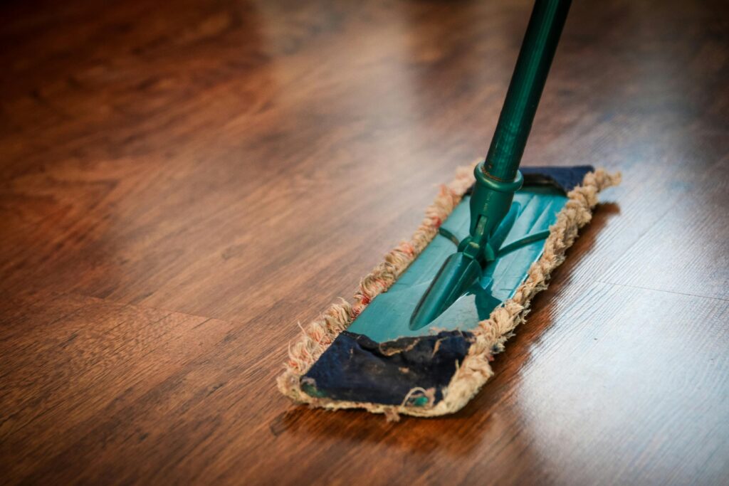 cleaning-washing-cleanup-the-ilo-48889-48889 A detailed view of a mop cleaning a wooden floor, showing texture and pattern.